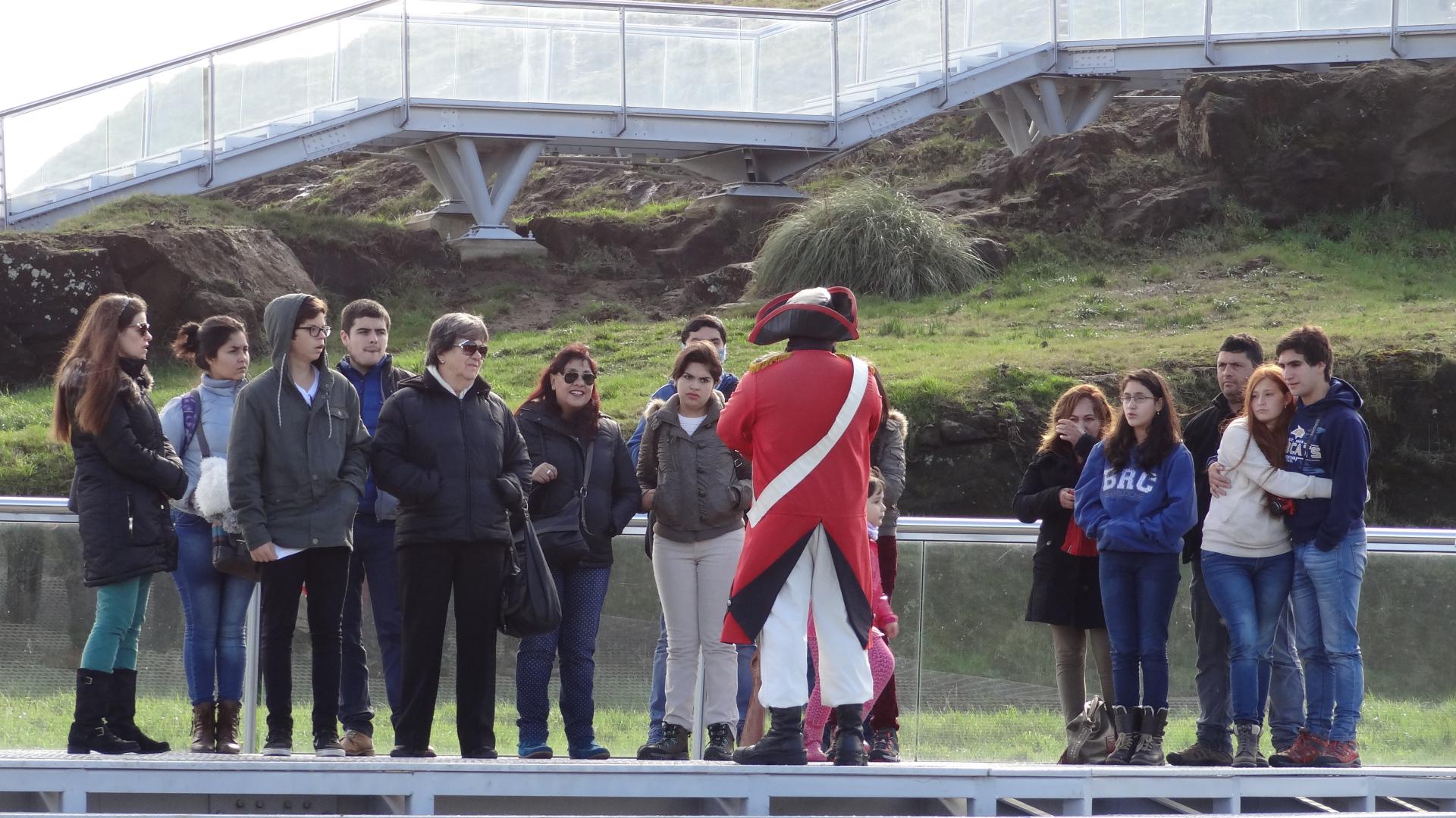 Visitantes disfrutan del relato del guía de época