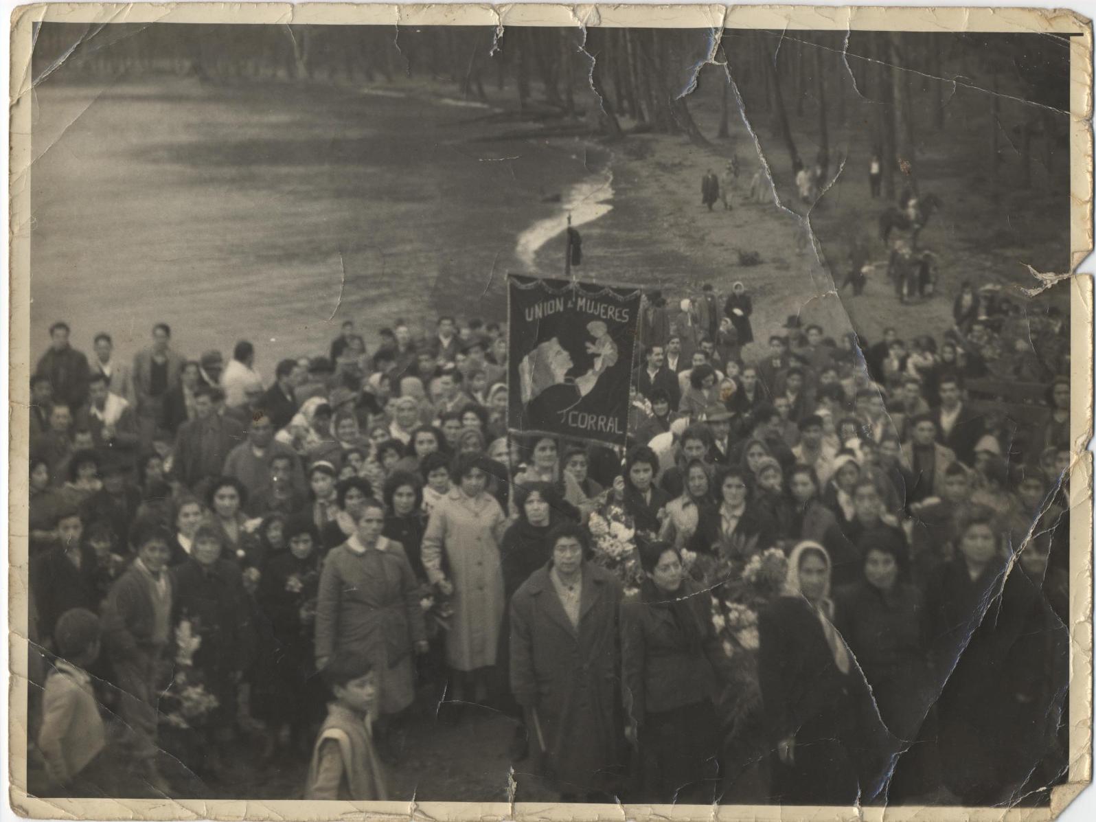 Marcha fúnebre de la Unión de Mujeres Pobladores de Corral recorren la ribera de la localidad de Amargos rumbo al cementerio, para asistir a un funeral de una integrante de la Unión de Mujeres de Corral. Año 1959.